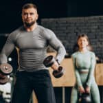 couple lifting dumbbells and kettlebell